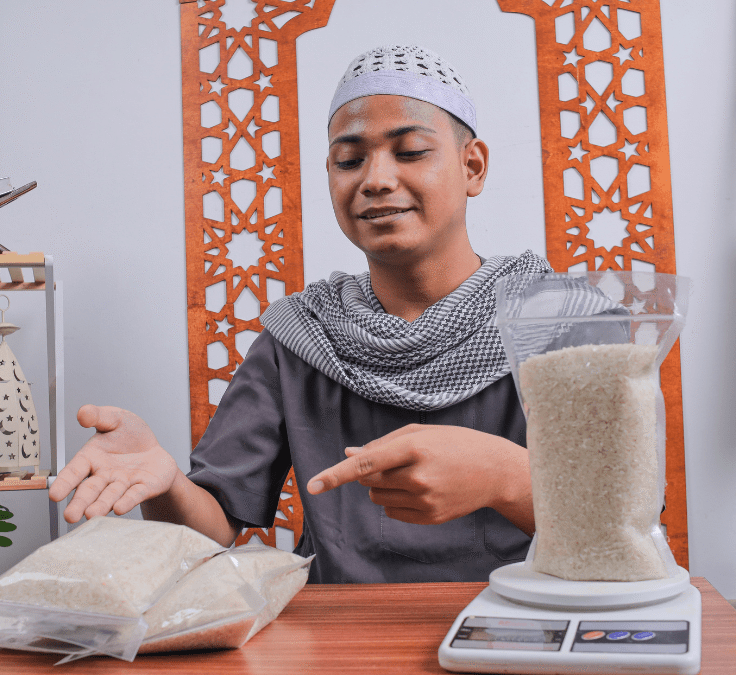 Hombre pesando y entregando arroz para calcular y dar el Zakat