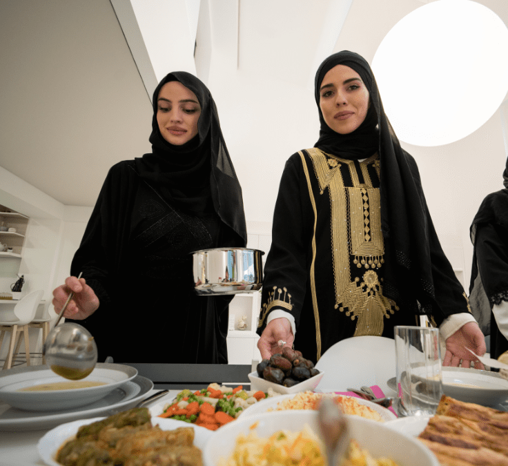 Dos mujeres musulmanas preparando y sirviendo comida para el rompimiento del ayuno en Ramadán