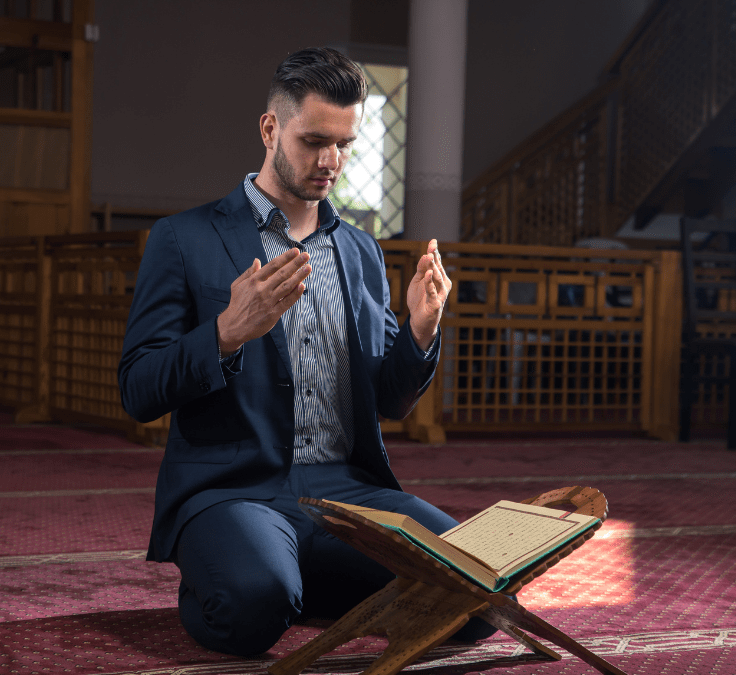 Hombre arrodillado con el Qurán abierto realizando duʿā por prosperidad y éxito