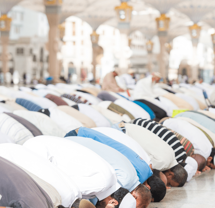 Musulmanes rezando en congregación en una mezquita realizando el Salat